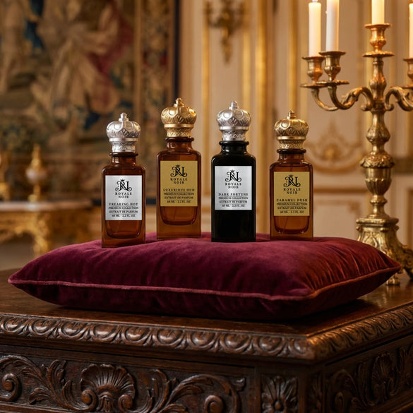 Royale Noir luxury fragrance collection featuring black, amber, and red glass bottles with crown-shaped caps in an elegant interior setting