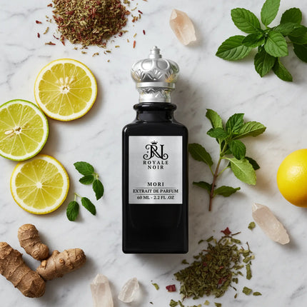 Perfume bottle labeled 'Royale Noire' surrounded by lemons, herbs, and spices on a marble surface.